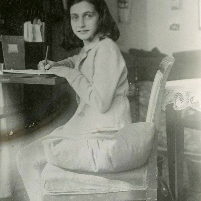 Anne Frank writing at a desk, a moment nearly lost to history that everyone should see.