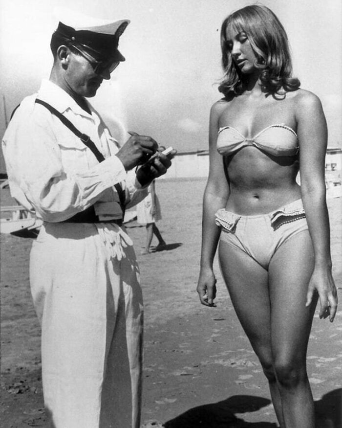 Policeman writing a ticket for a woman in a bikini, a moment nearly lost to history that everyone should see.