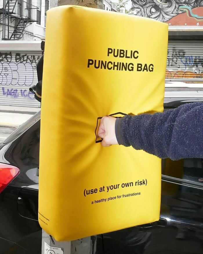 Brilliant and beautiful design: A person punching a yellow public punching bag on the street.