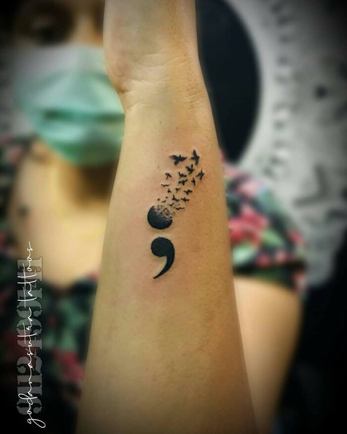 A semicolon tattoo with birds flying away from it, symbolizing a powerful story of freedom and hope.