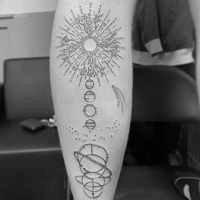 Geometric and cosmic leg tattoo ideas for women, showcasing a sun, planets, and abstract shapes in a unique pattern.