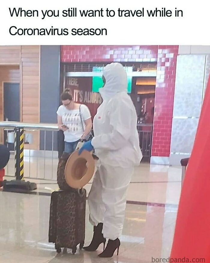 A person in a full white hazmat suit and heels at an airport with a suitcase, illustrating a travel memes situation during Coronavirus season.