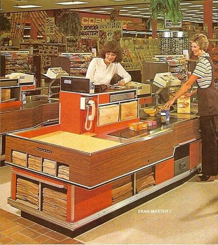 Historical Moments: Supermarket checkout with woman cashier and shopper, 1970s. Lost to History Moment.