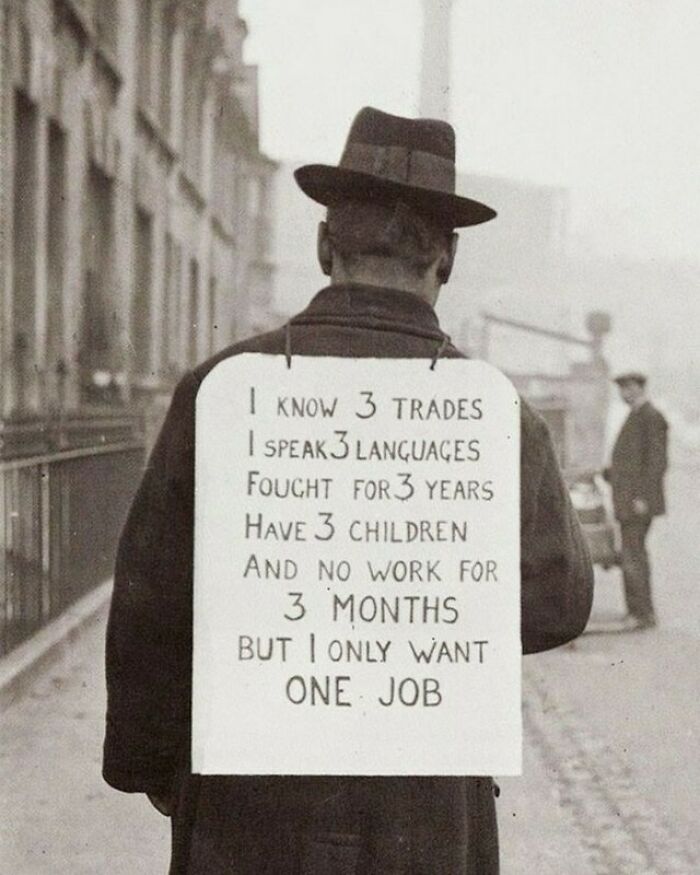 Man with a sign on his back saying he needs a job, a moment nearly lost to history.