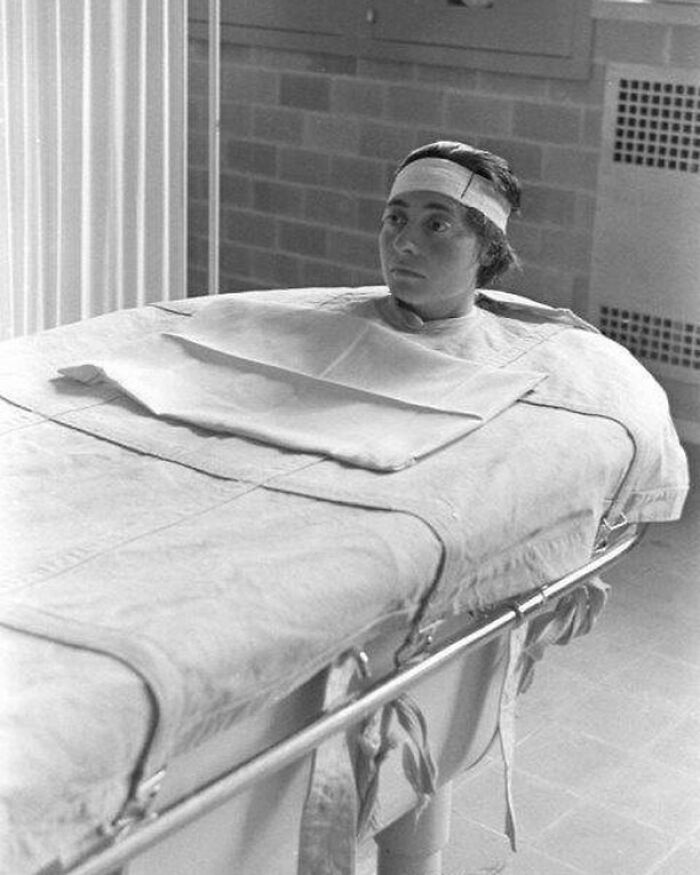 A patient on a gurney, undergoing a medical procedure, a historical moment in medicine.