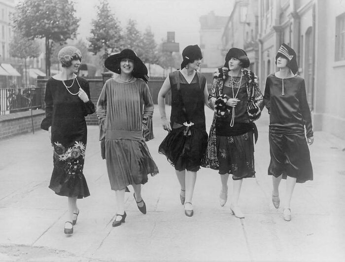 Five women in 1920s fashion walking on a sidewalk, showcasing moments nearly lost to history.