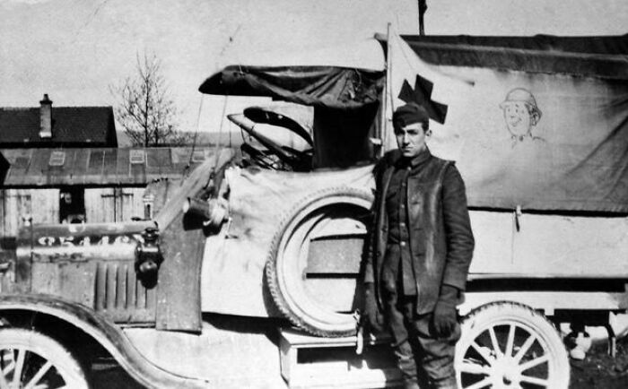 A soldier stands by an ambulance truck during wartime, a poignant moment nearly lost to history of military transport.