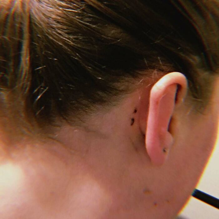 A small semicolon tattoo behind the ear, representing a powerful story of hope and resilience.