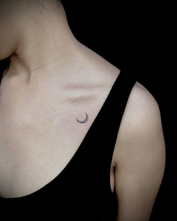 Minimalist moon tattoo ideas for women, featuring a small crescent moon on the collarbone, elegant and simple.