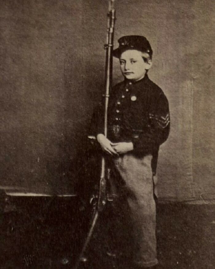 A young boy in a soldier's uniform holding a rifle, an important moment nearly lost to history.
