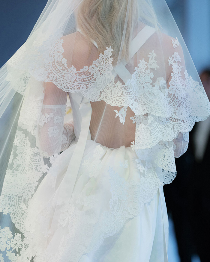 Close-up of a bride's back, showcasing intricate lace details on her wedding veil and gown, highlighting the wedding. Close-up of a bride's back, showcasing intricate lace details on her wedding veil and gown, highlighting the wedding.