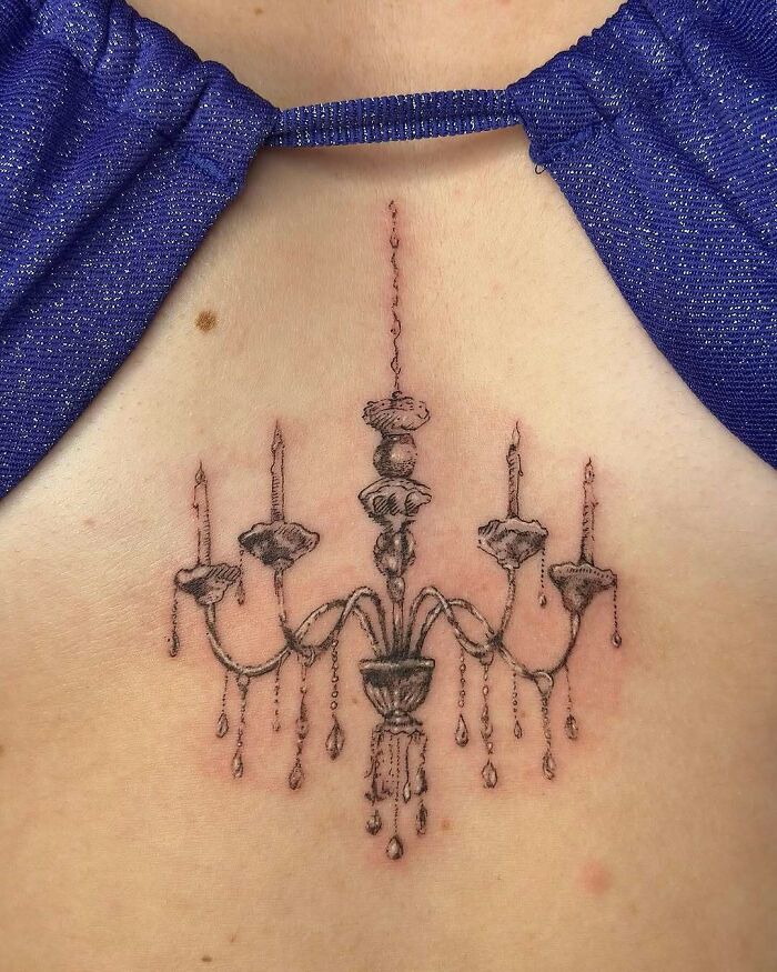Intricate chandelier chest tattoo ideas for women, a stylish and elegant design.