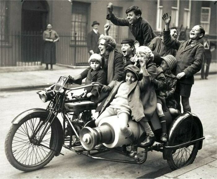 A black and white photo of many children joyfully riding in a motorcycle with a sidecar, a moment nearly lost to history.