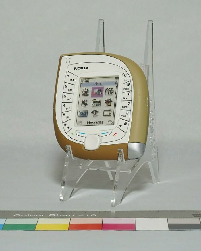 Beautiful design of a unique-shaped Nokia phone on a clear stand, highlighting brilliant design.