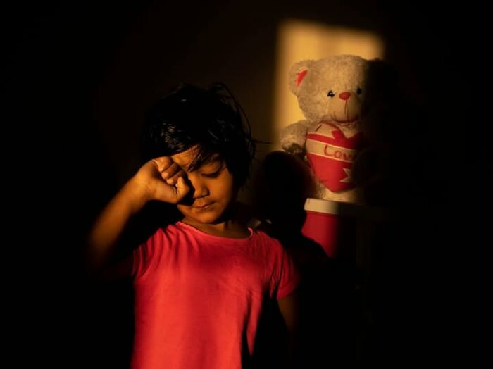 A captivating photograph by Tittu Shaji Thomas showing a child with a teddy bear, portraying life across cultures and landscapes.