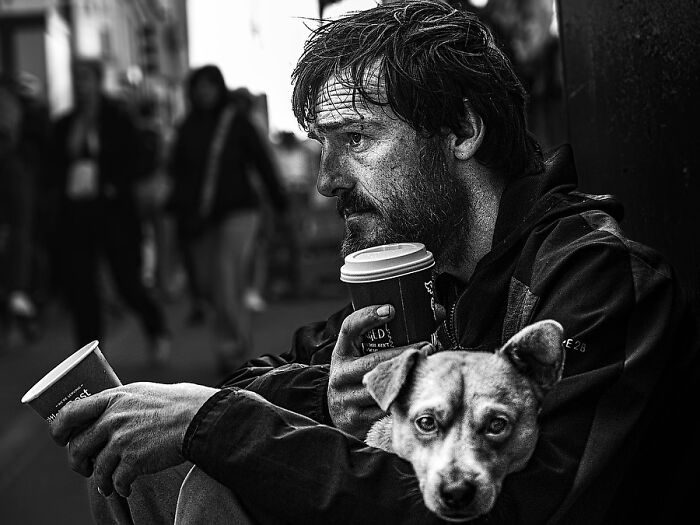 Remarkable photographs by Tittu Shaji Thomas capturing life: a man with a beard, coffee, and dog on a street.