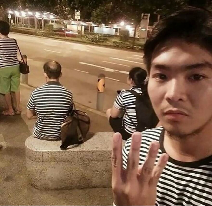A cursed image of a man taking a selfie, surrounded by multiple people wearing the exact same striped shirt.