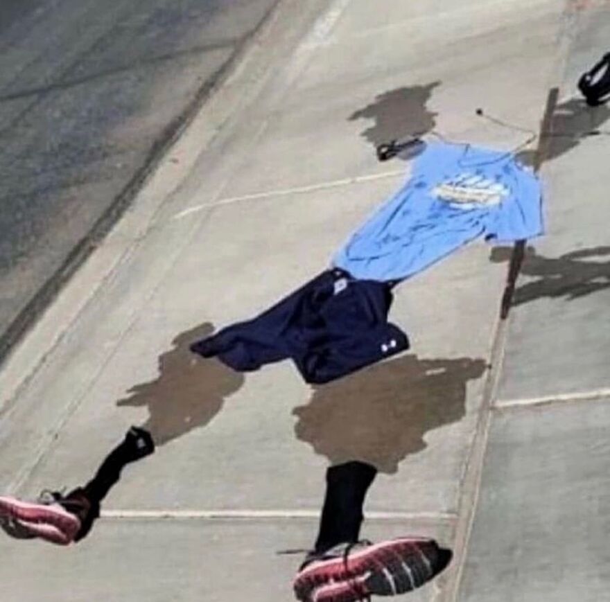 A cursed image showing clothing items arranged on the ground to create a shadow of an unhinged person, very random.