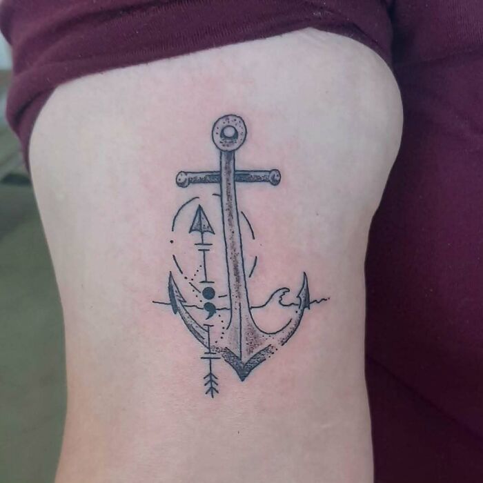 An anchor tattoo incorporating a semicolon symbol, representing a powerful story of hope and strength.