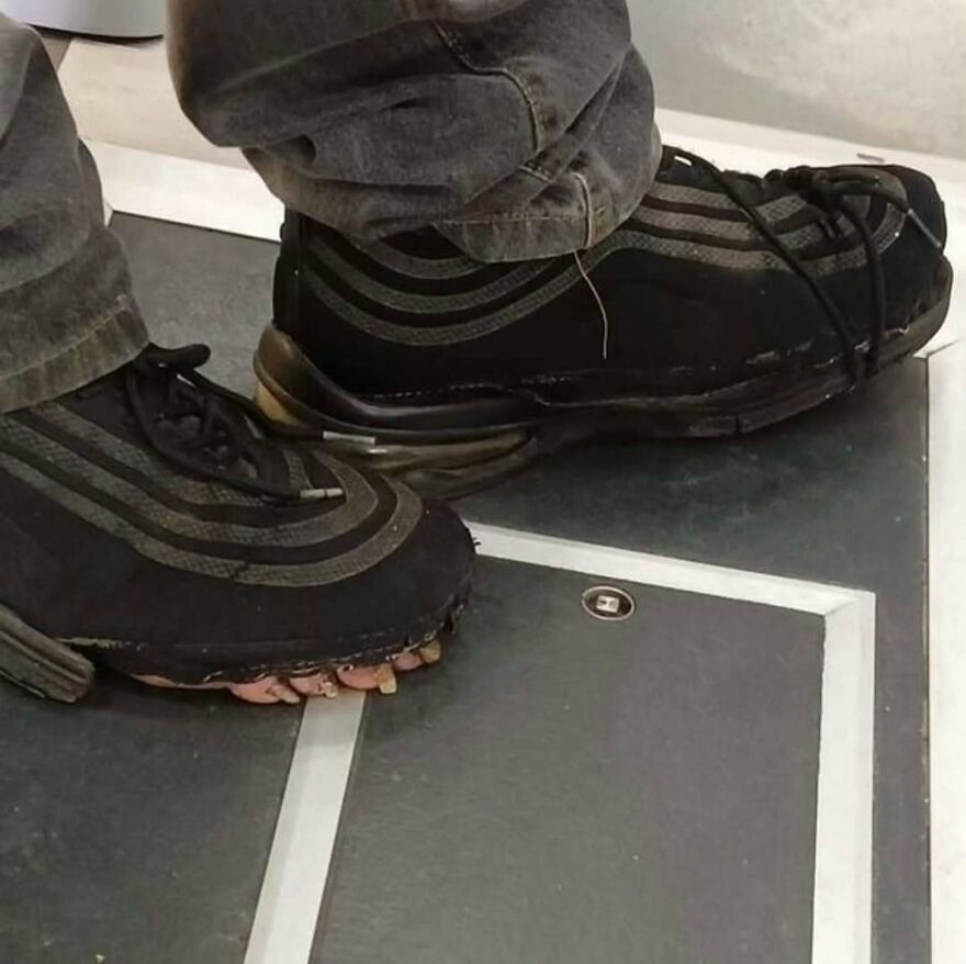 A pair of worn black sneakers with exposed toes, a cursed image of footwear.
