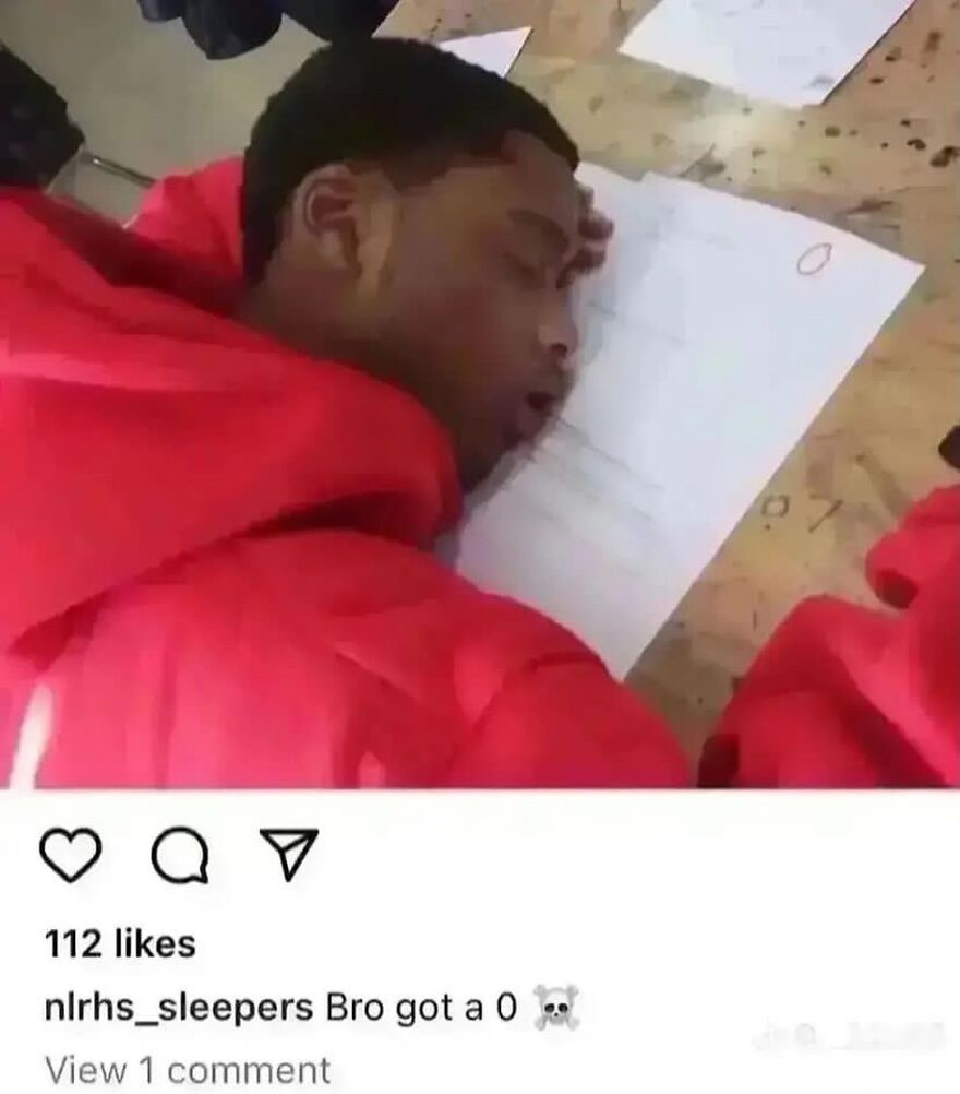 A student in a red hoodie asleep on a desk with a paper showing a 0, a random and unhinged moment.