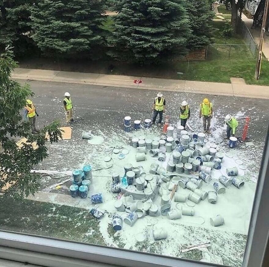 Construction workers looking at spilled paint cans on the street, an unhinged and cursed image.