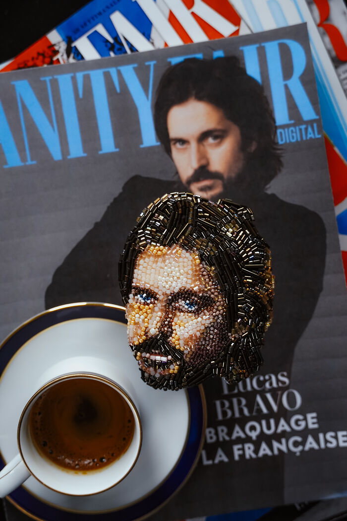 Beaded creation by Tiffany Pisani, a male portrait brooch, placed on a magazine featuring Lucas Bravo.