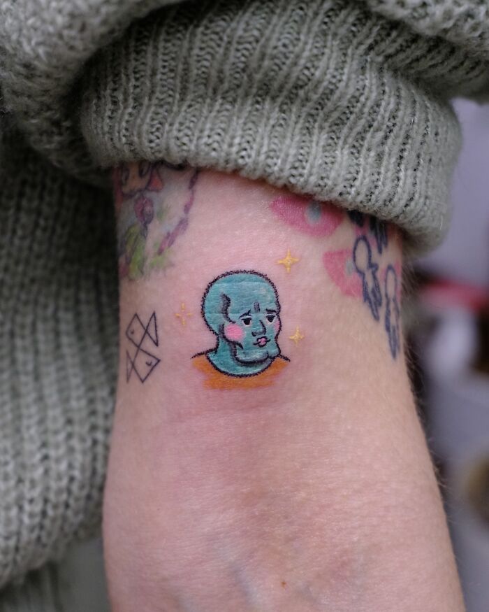 Unique Squidward-inspired tattoo in crayon drawing style, displaying unfiltered artistic creativity.