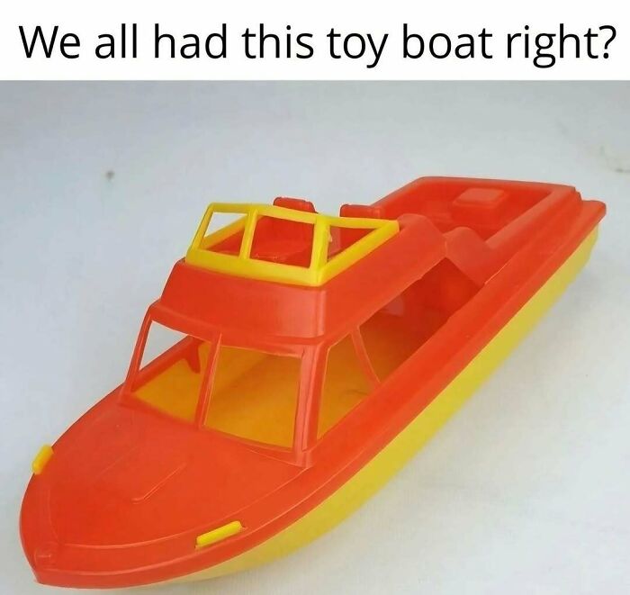 A bright orange and yellow toy boat, a nostalgic item reminding of good old Saturday mornings.