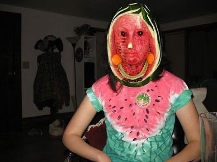 A person with a watermelon carved to fit their head as a mask, an unhinged and cursed image.