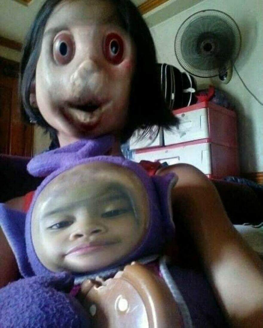 A distorted face in a mirror image with a baby on the lap, an unhinged and cursed image.