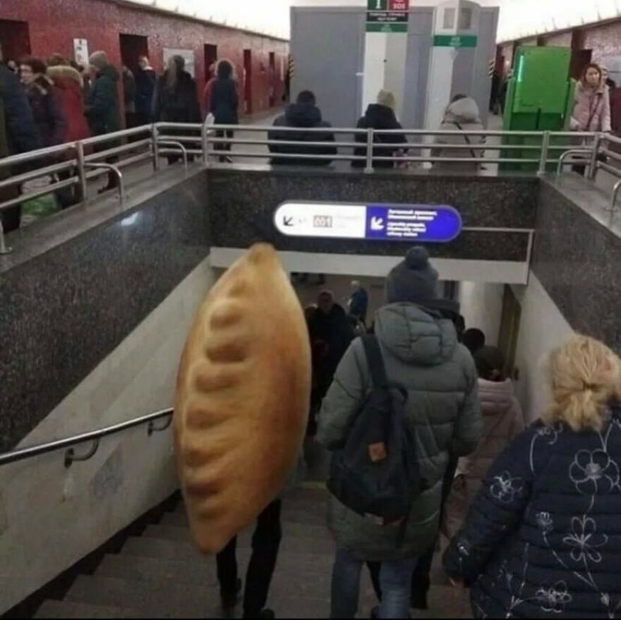 A cursed image of a person in a giant pierogi costume descending stairs in a busy public transit station.