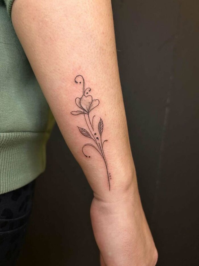 A delicate floral tattoo incorporating a semicolon, symbolizing a powerful story of growth and perseverance.
