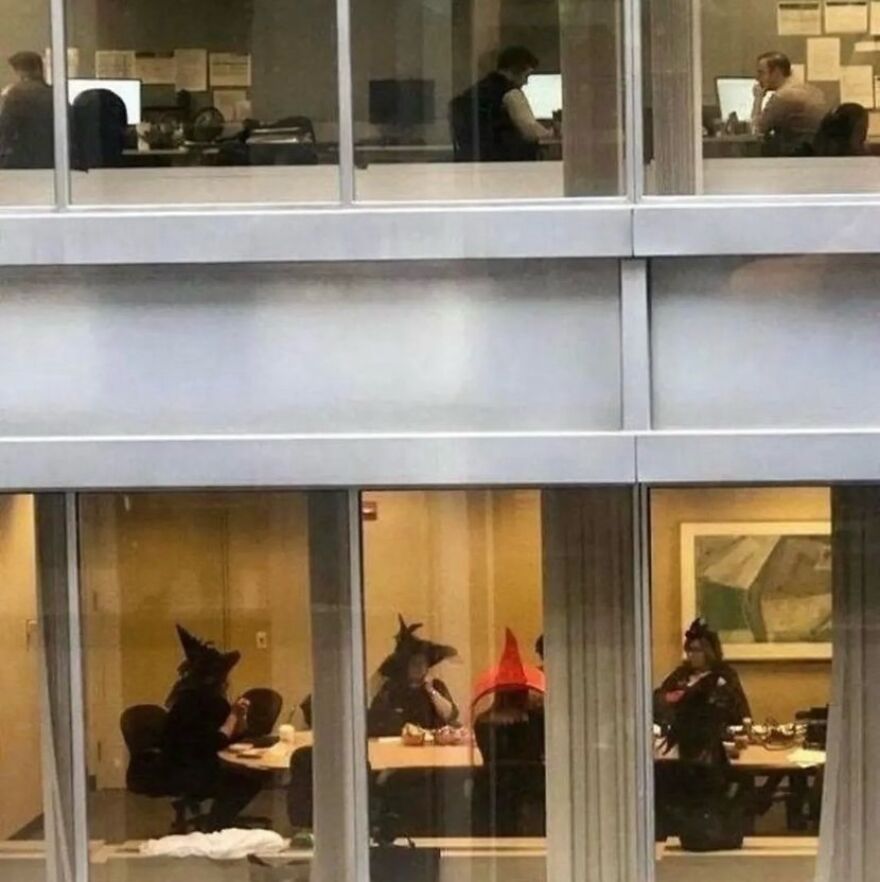 Office workers in witch hats and costumes, a truly random and cursed image.