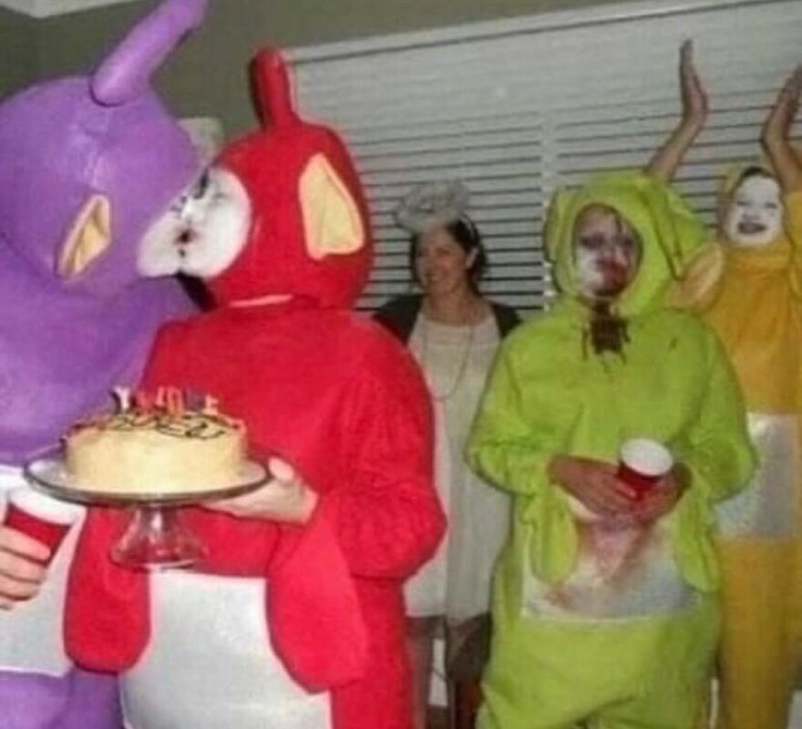 People in distressed Teletubbies costumes, one holding a cake, a cursed and unhinged image.