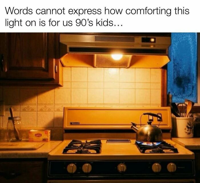 A warm, dimly lit kitchen with an old-fashioned stove and a kettle. The range hood light provides a comforting glow. Pure nostalgia gems.