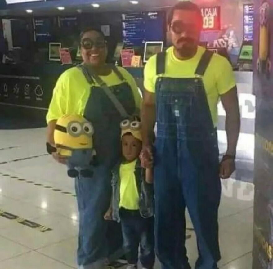 A family dressed in Minion costumes, smiling for a photo, making for cursed images.