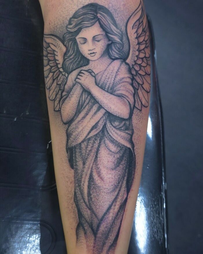 Angel tattoo ideas for women, a detailed black and grey forearm piece.