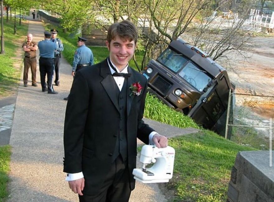 A man in a tuxedo holding a sewing machine next to an overturned truck, one of many cursed images.