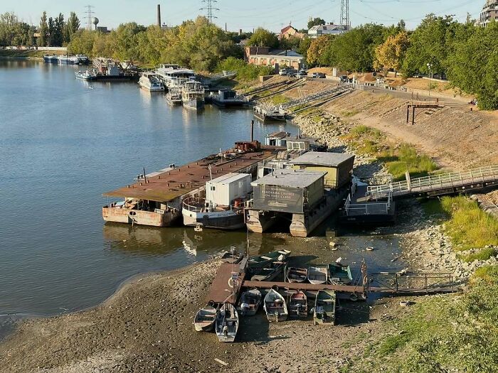 Low water levels reveal the riverbed and boats docked along the shore, a clear sign of Europe's brutal drought and its politics.