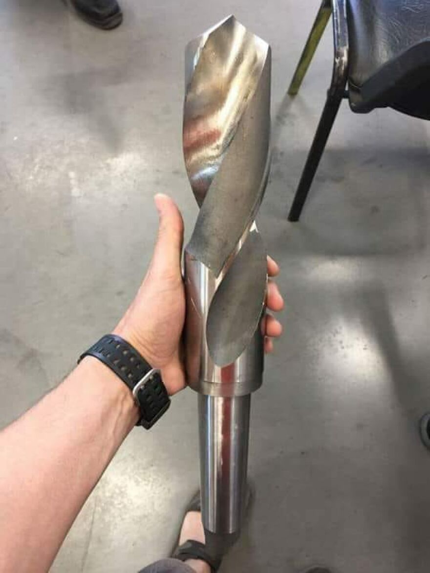 A hand holding a massive drill bit, highlighting a funny tool fail. Unfortunate tool fails.