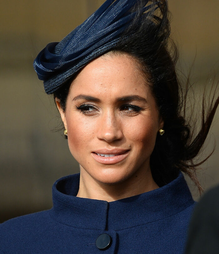 Meghan Markle smiles, wearing a blue hat and coat, on her birthday, facing karma and critics. Meghan Markle smiles, wearing a blue hat and coat, on her birthday, facing karma and critics.
