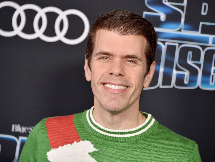 Perez Hilton in a green sweater, smiling at an event, as details of his crisis and darker reality emerge. Perez Hilton in a green sweater, smiling at an event, as details of his crisis and darker reality emerge.