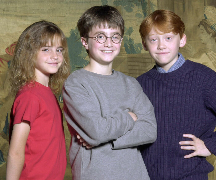 Young Rupert Grint (right), Daniel Radcliffe (center), and Emma Watson (left) pose for a Harry Potter promotional image. Young Rupert Grint (right), Daniel Radcliffe (center), and Emma Watson (left) pose for a Harry Potter promotional image.