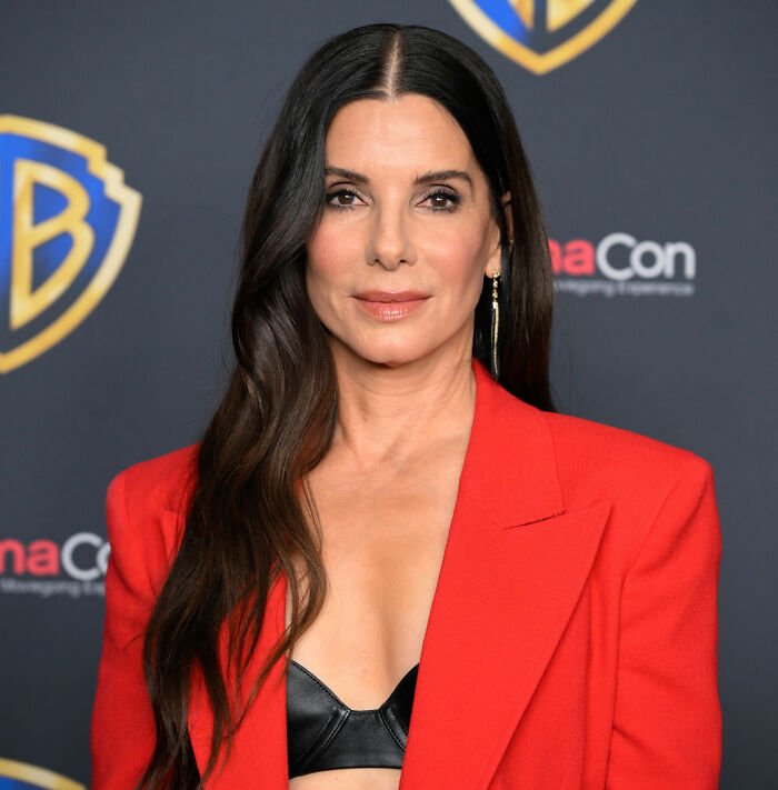 Sandra Bullock breaks silence, looking directly at the camera, wearing a red blazer and black top. Sandra Bullock breaks silence, looking directly at the camera, wearing a red blazer and black top.