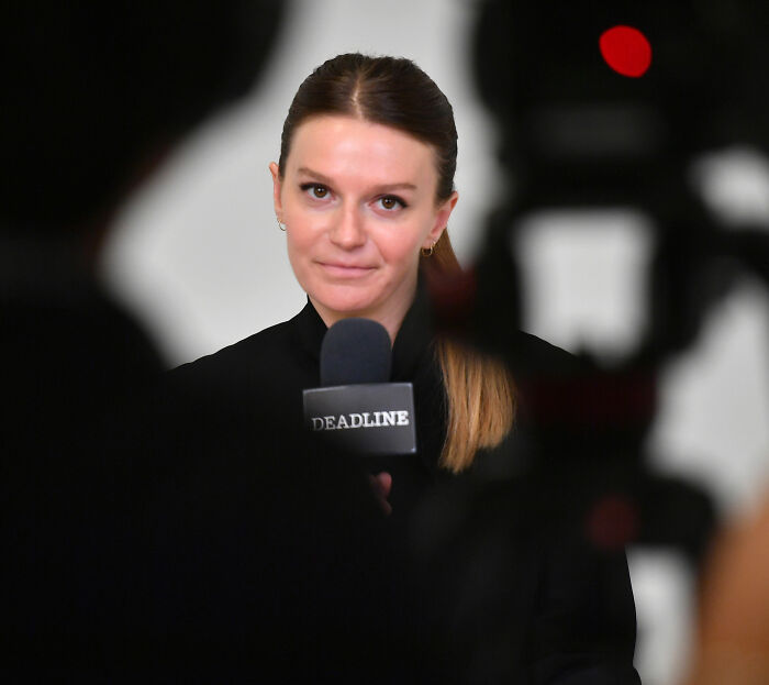 A woman, the Black Mirror director, holds a Deadline microphone, responding to a question about the Harry Potter series.