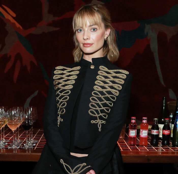 Margot Robbie in a black and gold military-style jacket, central to the rumored blockbuster franchise role. Margot Robbie in a black and gold military-style jacket, central to the rumored blockbuster franchise role.