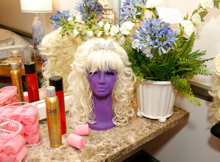 Blonde wig on a purple mannequin head, showcasing Dolly Parton's iconic wigs and hair. Blonde wig on a purple mannequin head, showcasing Dolly Parton's iconic wigs and hair.