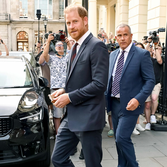 Prince Harry in a suit, walking past photographers, sparking scandalous theories about his and Meghan Markle's move back to UK. Prince Harry in a suit, walking past photographers, sparking scandalous theories about his and Meghan Markle's move back to UK.