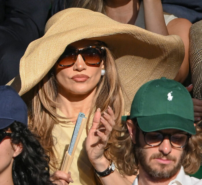 Jennifer Lopez, one of the celebrities, wearing a large hat and sunglasses at an event. Jennifer Lopez, one of the celebrities, wearing a large hat and sunglasses at an event.